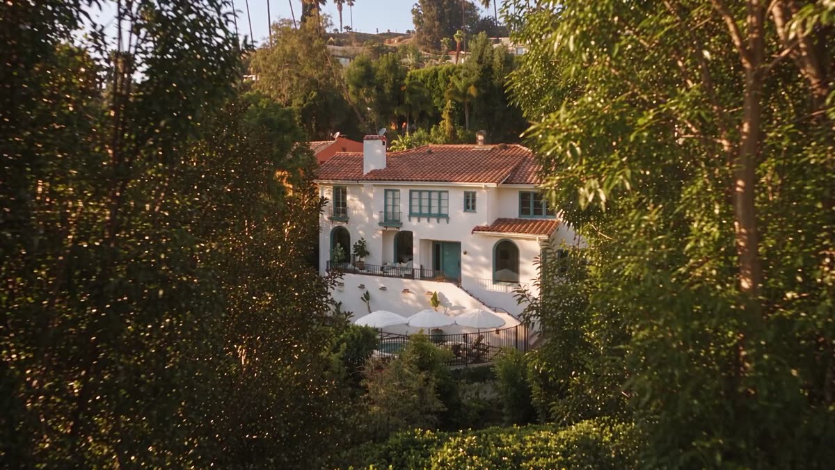 Camera descending toward the 1926 Spanish residence at 2126 E Live Oak Drive through the oaks