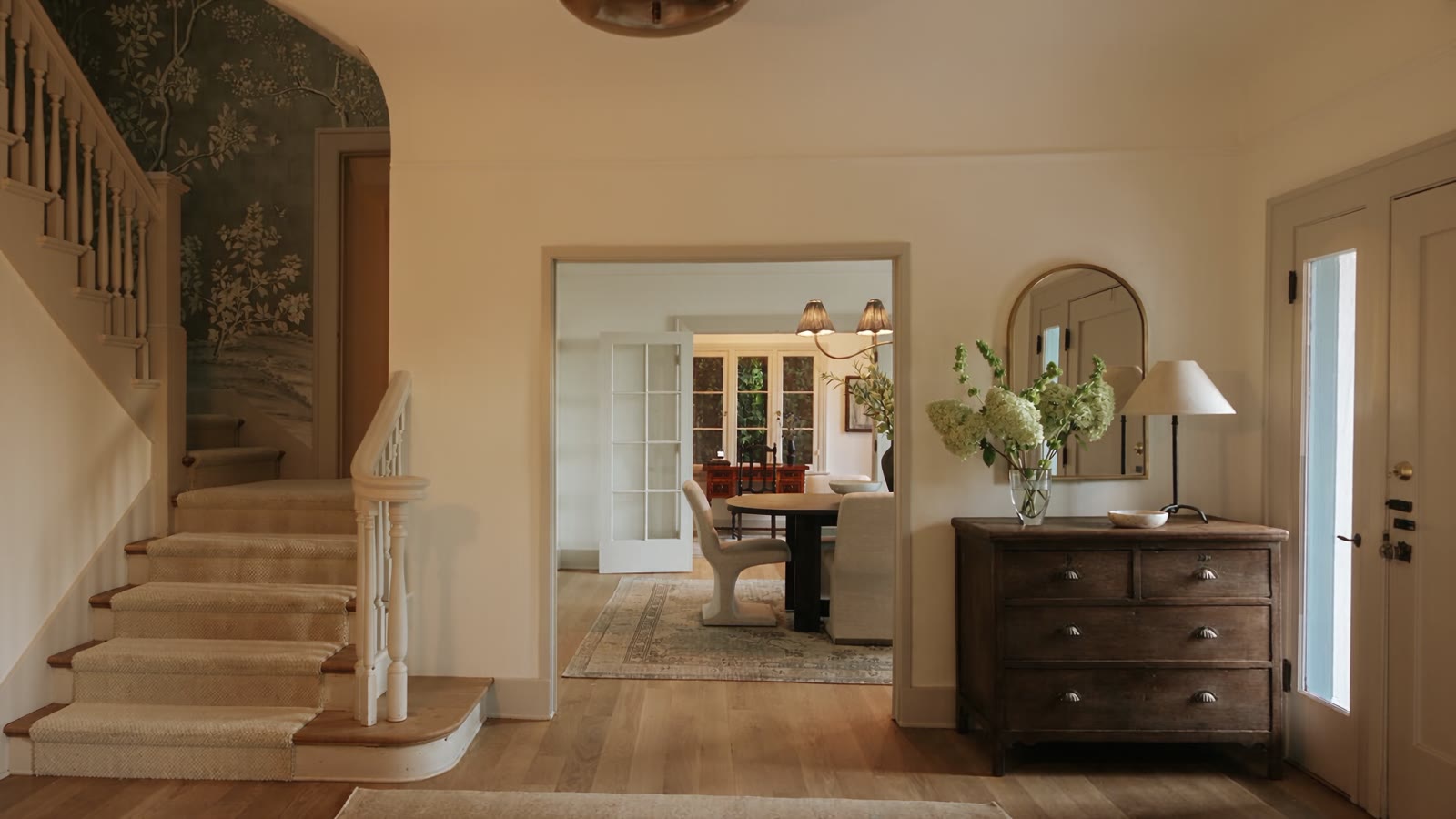 Camera moving through the entry hall past the curved stair toward the dining room