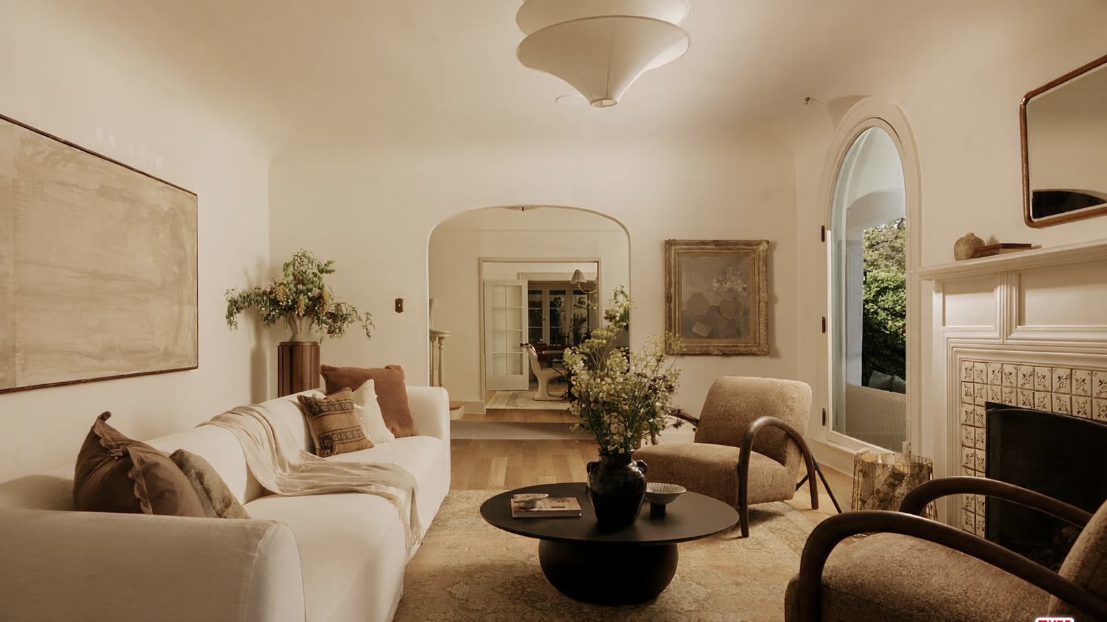 Camera travelling through the living room past the tiled fireplace toward the entry hall